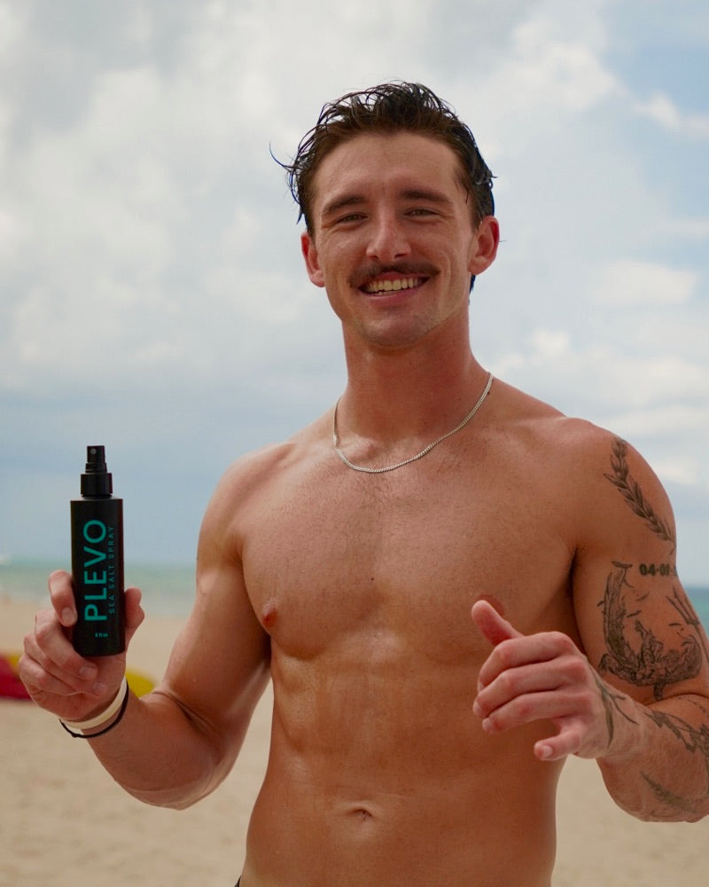 James on the beach, holding the bottle