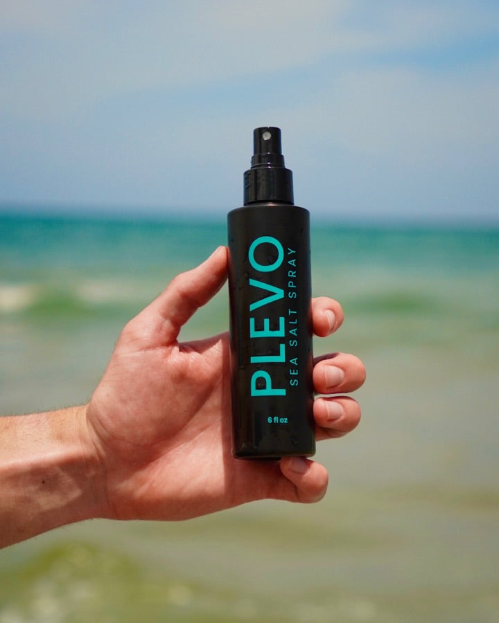 The bottle held in one hand against the open water, showing its size
