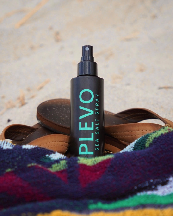 The bottle resting on a folded striped beach towel
